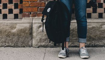 College student holding backpack.